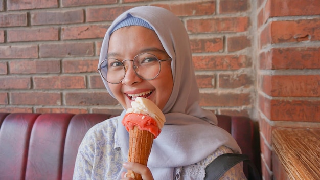 Fille hijab asiatique tout en dégustant une glace à la glace