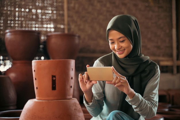 Fille en hijab utilisant un smartphone pour prendre une photo