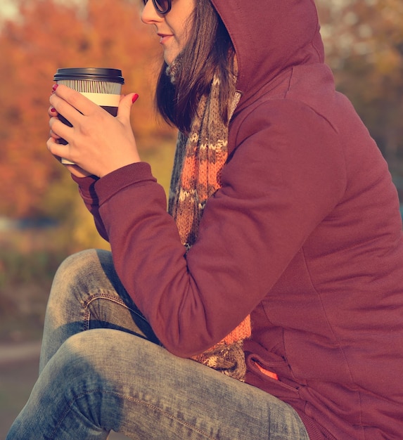 Fille hipster appréciant le café dans le parc