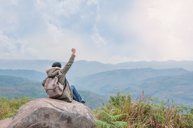 Fille de hipster assis dans les rochers de la montagne