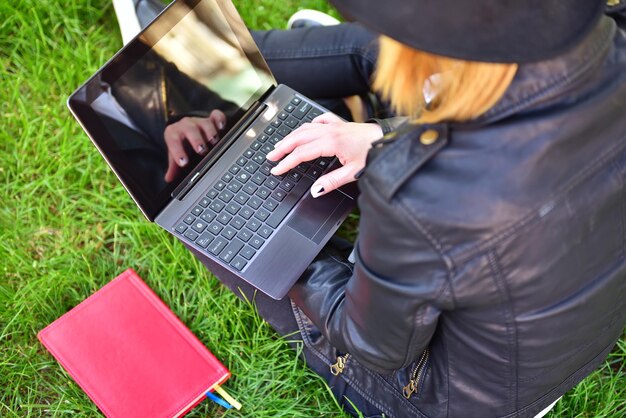 Fille hipster assise avec un ordinateur portable