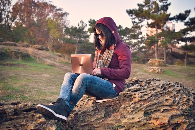 Fille hipster assise sur un rocher