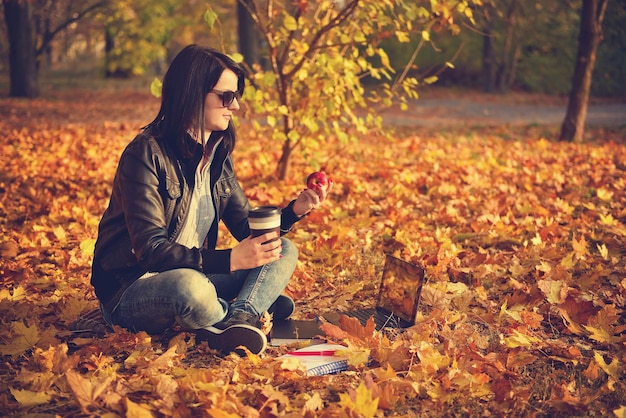 Fille hipster avec une tasse de café et un livre