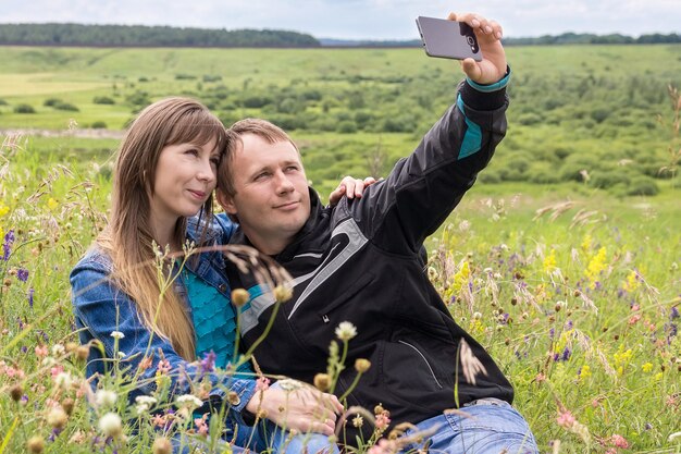 Fille et homme prenant des photos d&#39;eux-mêmes au téléphone