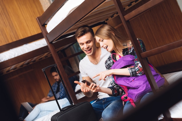 Fille et homme regardent le téléphone et rient ensemble.