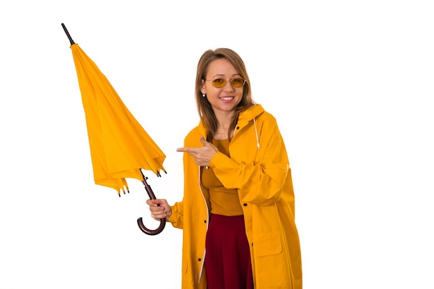 Une fille en imperméable jaune tient un parapluie dans ses mains. Isoler sur fond blanc