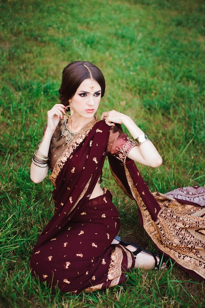 Fille indienne avec des bijoux orientaux et du henné de maquillage appliqué à la main. Brunette fille modèle hindou avec des bijoux indiens