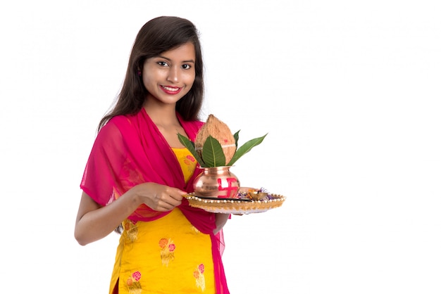 Photo fille indienne tenant un kalash traditionnel en cuivre avec pooja thali, festival indien, kalash en cuivre avec noix de coco et feuille de manguier à décor floral, indispensable dans le hindou pooja.