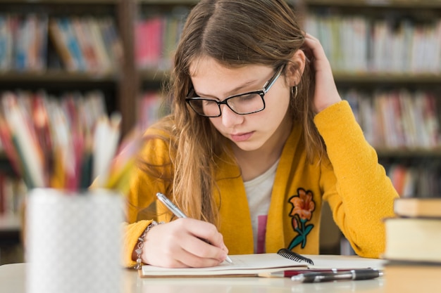 Fille Intelligente étudie Dans La Bibliothèque