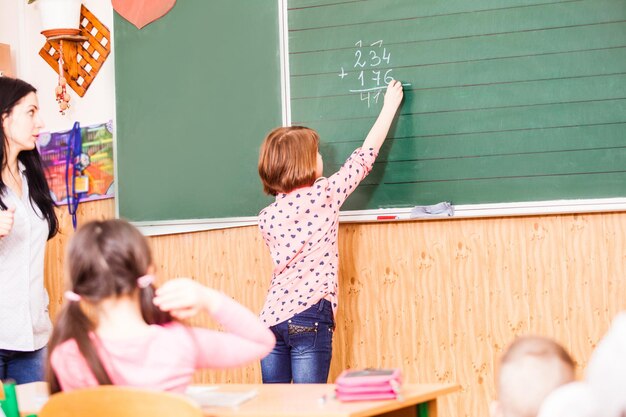 Fille intelligente veut répondre à la question sur la leçon et obtenir une bonne note