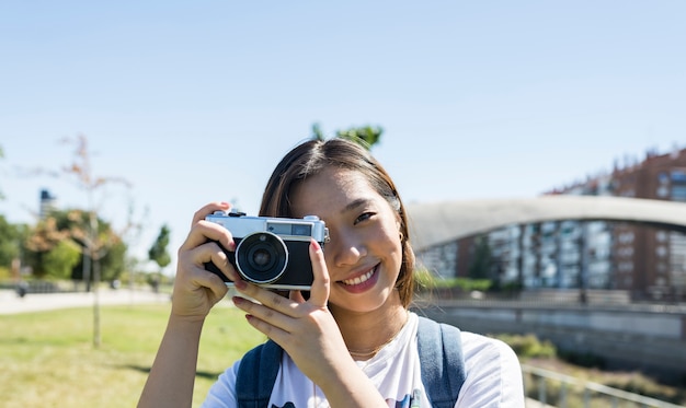 Fille japonaise avec un appareil photo, fond de ciel, espace copie