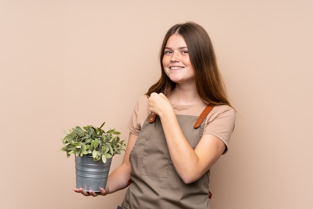 Fille de jardinier adolescente ukrainienne tenant une plante célébrant une victoire