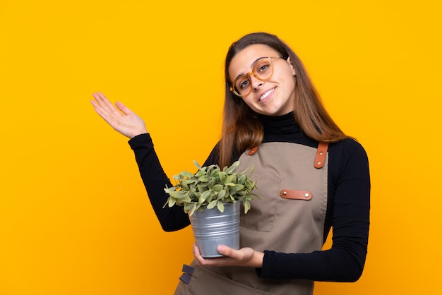 Fille de jardinier sur mur jaune isolé