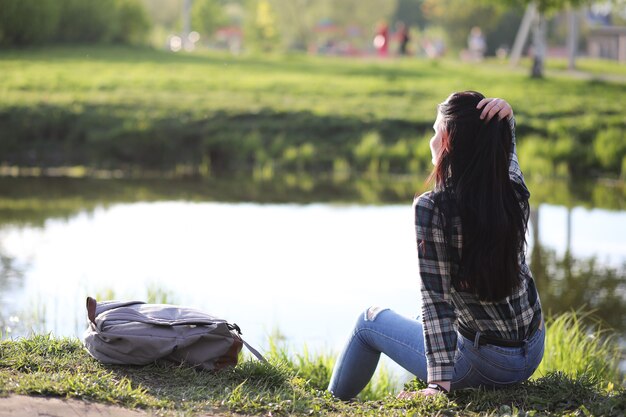 Une fille en jeans et chapeau parcourt l'été à la campagne