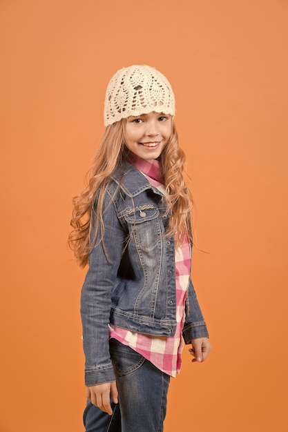 Fille en jeans costume chapeau chemise à carreaux sur fond orange