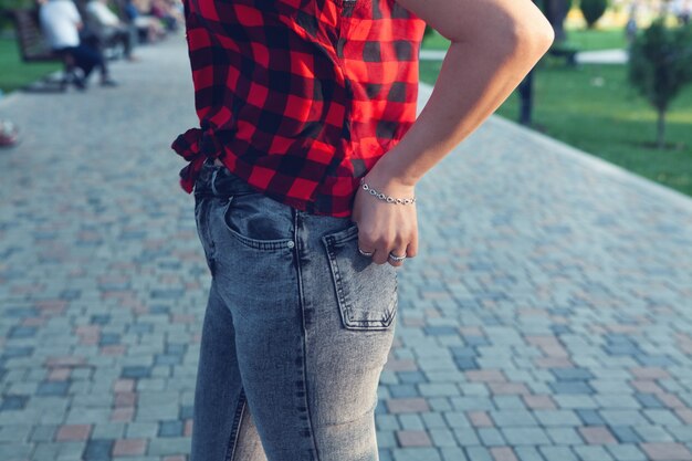 Fille en jeans debout dans le parc