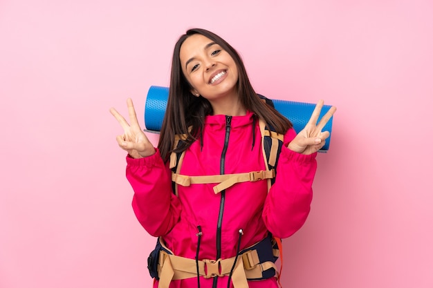 Fille jeune alpiniste avec un gros sac à dos isolé