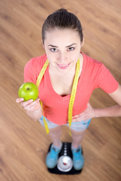 Fille jeune belle fitness debout sur le poids.