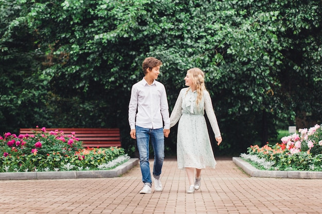 Fille et jeune homme assis sur un banc, premier rendez-vous, baiser de communication, connaissance