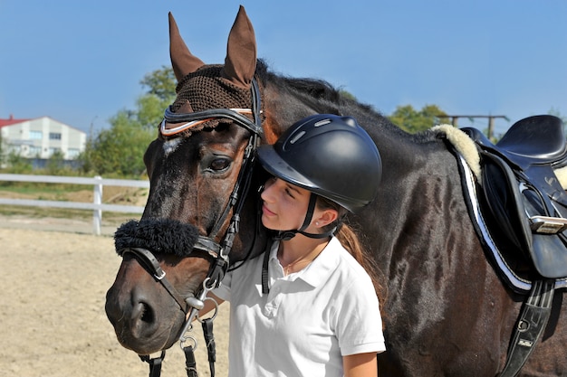 Fille jockey à la ferme avec son cheval