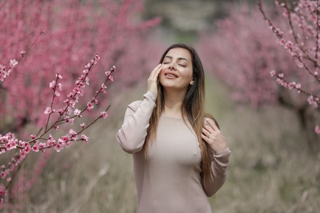 Fille avec une jolie silhouette dans des vêtements serrés au printemps dans le jardin