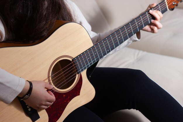 Fille jouant un accord sur une guitare acoustique Concept de détente