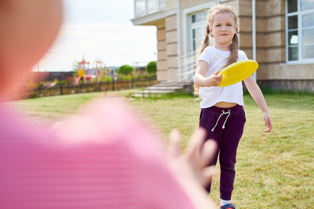 Fille jouant au frisbee avec des amis