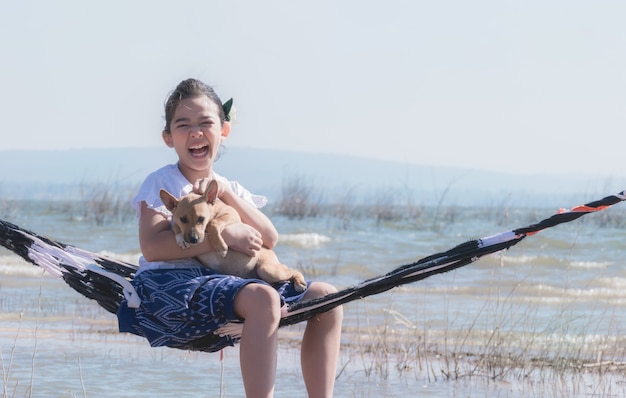 Fille jouant avec un chien sur un hamac