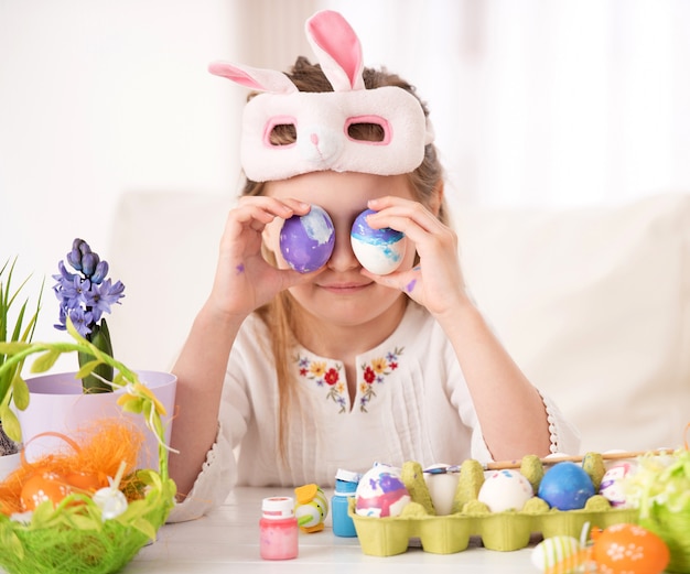 Fille jouant avec la collection d'oeufs de Pâques