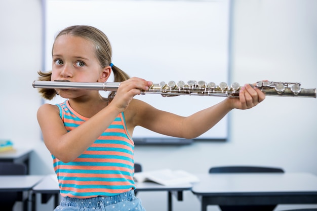 Fille jouant de la flûte en classe