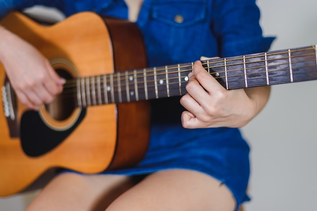 Fille jouant de la guitare acoustique isoler sur blanc