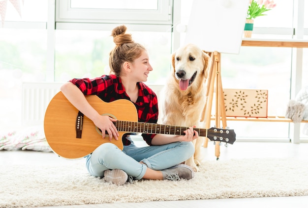 Fille jouant de la guitare avec un beau chien