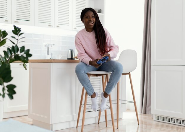 Fille jouant à des jeux vidéo à la maison plein coup