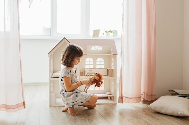 Fille jouant avec la maison de poupée