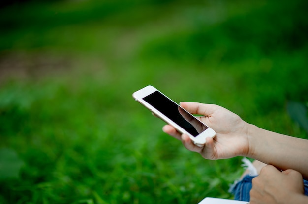 Fille jouant un téléphone sur place pour la communication et le contact en ligne