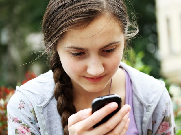 Fille jouant sur téléphone portable