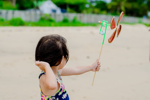 Fille jouant une turbine à la plage.