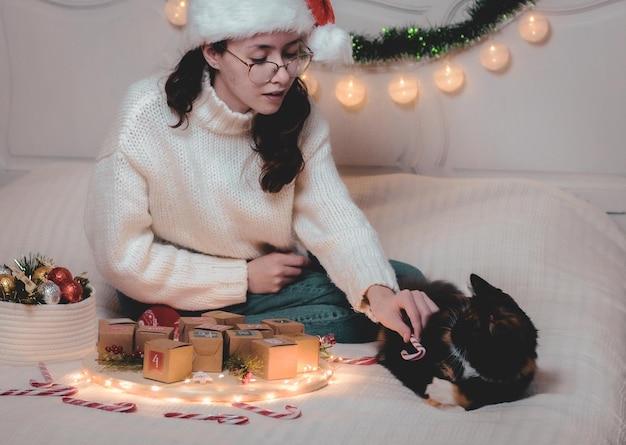 La fille joue avec le chat sur le lit