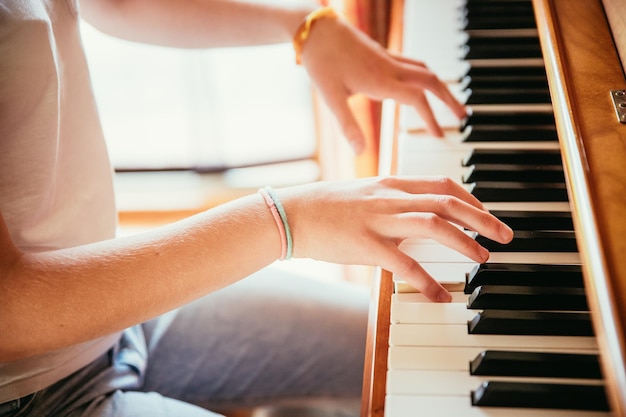 Fille joue du piano à la maison vue grand angle arrière-plan flou