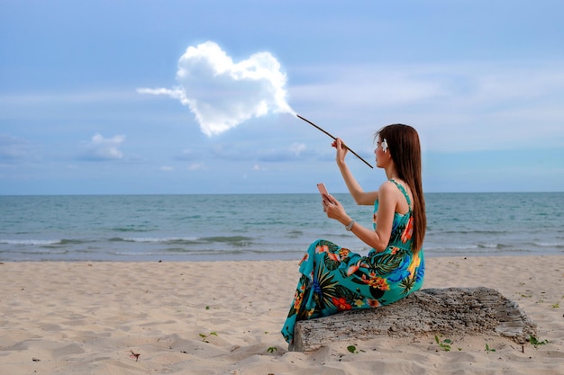 La fille joue à l'eau de mer Vague dans le vent