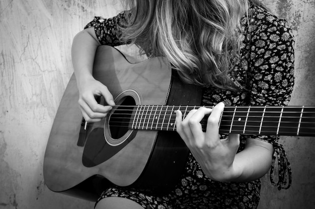 La fille joue de la guitare acoustique