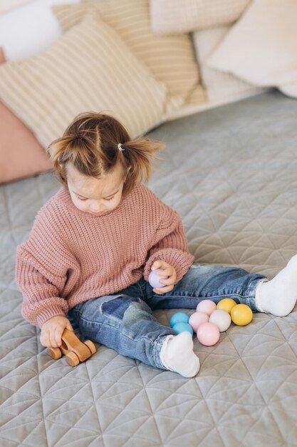 Photo fille joue des jouets dans le salon jouet en bois montessori pyramide pliée cercle triangle rectangle éléments en bois de jouets pour enfants jouet coloré bleu jaune rouge vert