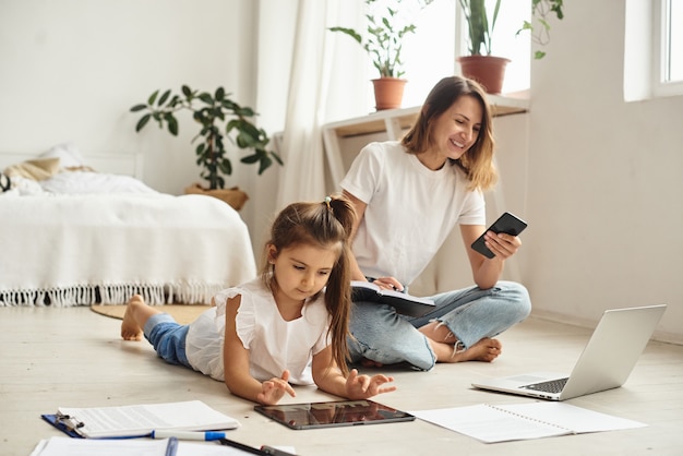 Fille joue avec maman et chat pendant que maman travaille sur ordinateur