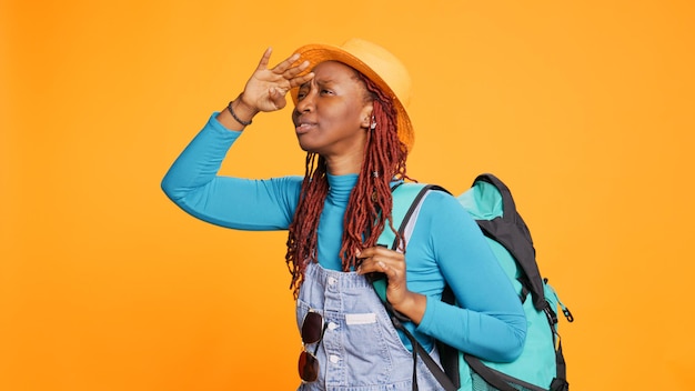 Fille joyeuse admirant la route panoramique en voyage de vacances, regardant autour de la ville à l'architecture des bâtiments. Jeune voyageur avec sac à dos, visite touristique, vérification des points de repère en vacances. Prise de vue à main levée.