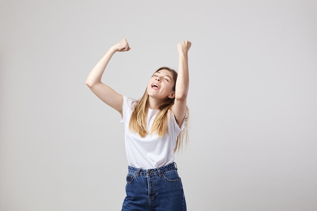 une fille joyeuse et calme vêtue d'un t-shirt blanc et d'un jean s'amuse