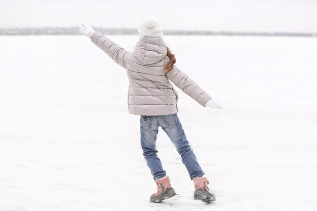 Fille joyeuse dans une belle tenue chaude s'amusant à l'extérieur