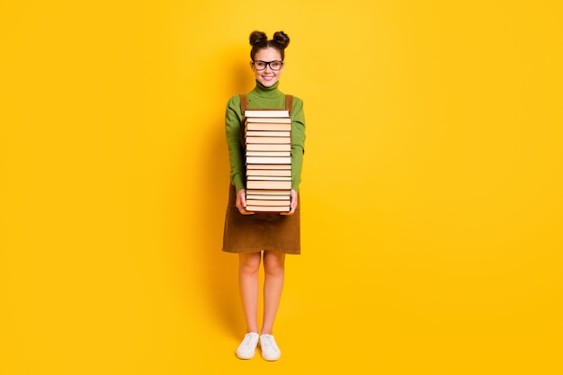 fille joyeuse diligente nerd transportant de nombreux livres à l'école 1er septembre automne