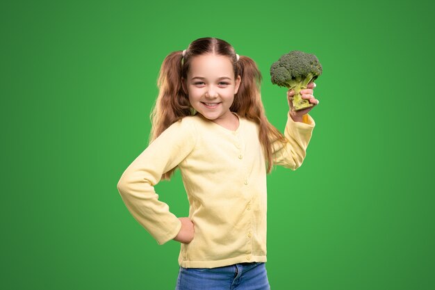 Fille joyeuse avec du brocoli frais en studio