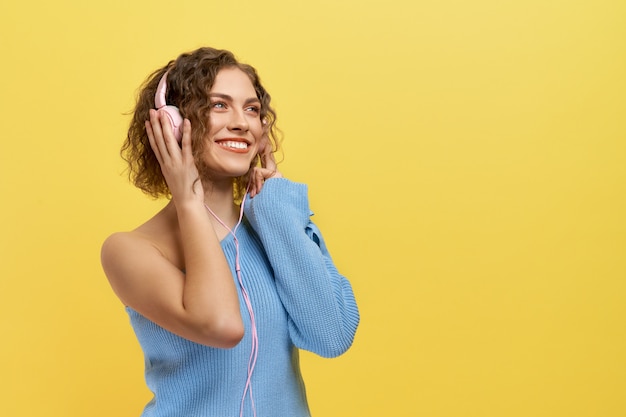 Fille joyeuse, écouter de la musique avec des écouteurs, souriant.