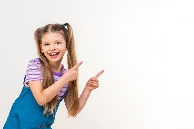 La fille joyeuse pointe avec ses mains la publicité.